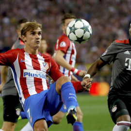El defensa austriaco del Bayern Munich David Alaba lucha el balón con el delantero francés Antoine Griezmann, del Atlético de Madrid, durante el partido de la segunda jornada de la fase de grupos de la Liga de Campeones que se juega esta no