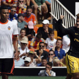El delantero francés del Atlético de Madrid Antoine Griezmann (d), celebra el gol conseguido frente al Valencia, el del 0-1, en presencia del defensa brasileño del Valencia, Aderllan Santos. / EFE