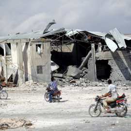 Varios hombres llegan con sus motos hacia uno de los lugares que, según la oposición siria, han sido bombardeados por la aviación rusa. REUTERS/Khalil Ashawi