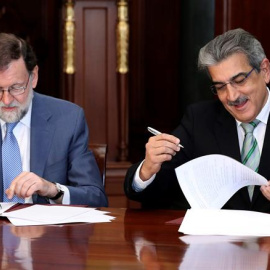 El presidente del Gobierno, Mariano Rajoy (i), y el de Nueva Canarias, Román Rodríguez (d), firmaron hoy en Las Palmas de Gran Canaria el acuerdo por el que la formación nacionalista apoyará los Presupuestos Generales del Estado 2018 a camb
