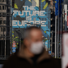  Un hombre con mascarilla pasa por delante del edificio de la Comisión Europea, en Bruselas. AFP/Aris Oikonomou