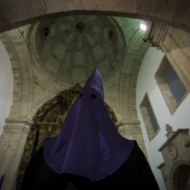 A hooded penitent of the "Numeraria del Rosario" brotherhood waits for the start of the Santo Entierro procession at the San Domingos de Bonaval church, during Holy Week in Santiago de Compostela, northwestern Spain, on March 25, 2016. Chri