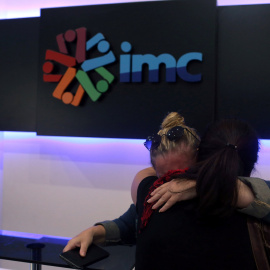 Dos trabajadores de IMC TV se abrazan justo después de que la Policía turca haya cerrado la redacción del canal. - REUTERS