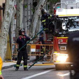 Los bomberos del Ayuntamiento tratan de localizar entre los escombros del edificio derrumbado a dos obreros. - EFE