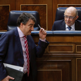 El ministro de Hacienda, Cristóbal Montoro, conversa con el portavoz del PNV, Aitor Esteban, durante el Pleno del Congreso que vota la totalidad del proyecto de Ley de Presupuestos Generales del Estado de 2018. EFE/Emilio Naranjo