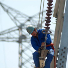 Un trabajador instala nuevas líneas de alto voltaje en una torre de electricidad. EFE/Archivo