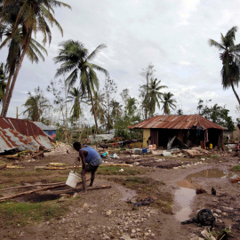 Un hombre recoge agua de una zona destrozada por el huracán Matthew, en Cavaillon, Haití. - REUTERS