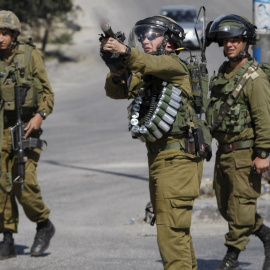 Un militar israelí lanza gases lacrimógenos para sofocar una protesta de palestinos en Hebrón. - REUTERS