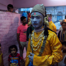 Un artista indio vestido como el dios hindú Rama, se coloca debajo de un ventilador para secar su maquillaje antes de una procesión religiosa que se celebra en el festival de Dussehra en Allahabad, el 14 de octubre de 2015. AFP/SANJAY Kanoj
