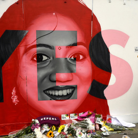 Una mujer observa un mural de Savita Halappanavar con ofrendas de flores en Dublín el día del referéndum en Irlanda sobre la liberalización del aborto. REUTERS/Clodagh Kilcoyne