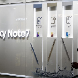 Una mujer mira su móvil junto a varios anuncios del Samsung Galaxy Note 7 en la sede de la compañía en Seúl. REUTERS/Kim Hong-Ji