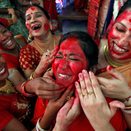 Varias mujeres indias echan sindhur' (polvo bermellón) a una de ellas durante un acto religioso en la ciudad de Chandigarh. - REUTERS