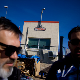 Dos trabajadores de Coca-Cola conversan en el campamento de protesta a las puertas de planta, que lleva un año cerrada. -JAIRO VARGAS