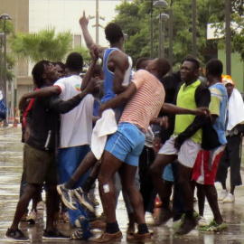 Un grupo de origen subsahariano celebra a las puertas del CETI de Melilla su entrada en la ciudad autónoma tras conseguir saltar la valla fronteriza con Marruecos.-- EFE/P. Sánchez