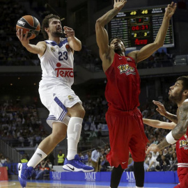 El base del Real Madrid, Sergio Llull (i), entra a canasta ante la defensa del ala-pivot canadiense de Olympiacos, Khem Birch. /EFE