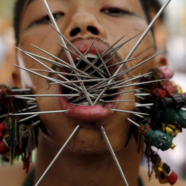 Un devoto del santuario chino Samkong  camina con agujas que le atraviesan las mejillas durante una procesión que celebra el festival anual vegetariano en Phuket, Tailandia, 16 de octubre de 2015. REUTERS / Jorge Silva