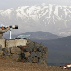 Un miembro de UNDOF observa con unos binoculares el monte Bental, en el Golan. REUTERS