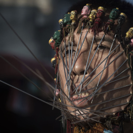 Un devoto del chino del Santuario Jui Tui tiene el rostro perforado por varillas metálicas durante una procesión durante el Festival anual Vegetariano en la ciudad sureña tailandesa de Phuket. AFP / Nicolas ASFOURI
