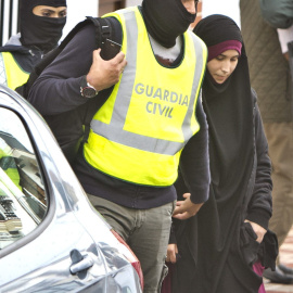 Efectivos de la Guardia Civil acompañan a la joven onubense de 22 años detenida en el aeropuerto de Madrid-Barajas cuando intentaba viajar para integrarse en el Estado Islámico. EFE / Julián Pérez