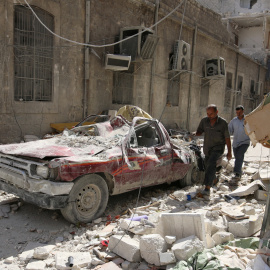 Dos personas pasan por una calle de Alepo destrozada por los últimos bombardeos. - REUTERS