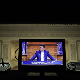 La imagen del primer ministro griego, Alexis Tsipras, en un monitor de una cabina de traduccióm simultánera, durante una reunión con los diputados de Syriza en el Parlamento heleno. REUTERS/Kostas Tsironis