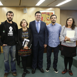 El portavoz adjunto de Unidos Podemos, Alberto Garzón, y la portavoz de Administraciones Públicas de la formación, Auxiliadora Honorato, junto a cargos de grupos municipales de diversas ciudades, durante la presentación del denominado 'Mani