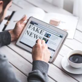 Un hombre sostiene una 'tablet' con las palabras "fake news" en la pantalla.- Pixabay