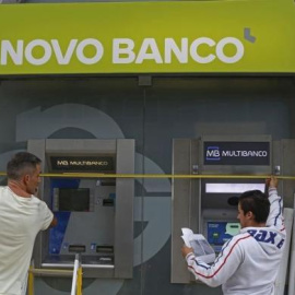 Unos trabajadores instalan el nuevo logo del portugués Novo Banco en una de sus sucursales de Lisboa. REUTERS