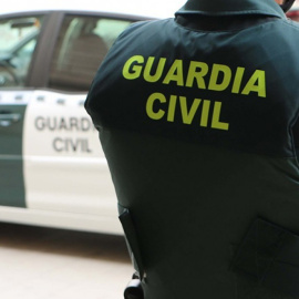 Un agente de la Guardia Civil junto a un coche.