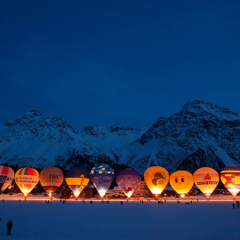 Los espectadores toman fotos de los globos aerostáticos, durante la Semana Internacional del Globo en la localidad suiza de Arosa. /CHRISTIAN HARTMANN (REUTERS)