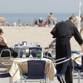 Un camarero atiende a una pareja en una terraza este verano. /EFE