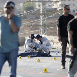 Varios policías israelíes recopilan pruebas junto al cuerpo sin vida de un palestino que ha sido abatido a tiros por un soldado israelí tras apuñalar a una joven en el asentamiento de Adam el martes. EFE