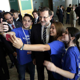 El presidente del Gobierno, Mariano Rajoy, se hace una foto con unos jóvenes a su llegadaa la segunda jornada del congreso que el Partido Popular Europeo celebra en Madrid. / ZIPI (EFE)