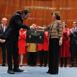 El líder de Podemos y nuevo vicepresidente de Derechos Sociales, Pablo Iglesias, hace una pequeña reverencia al recibir la cartera de manos de la vicepresidenta Carmen Calvo, en el acto de toma de posesión. REUTERS/Susana Vera