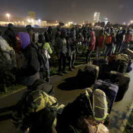 Refugiados del campo de refugiados de Calais esperando el traslado a los centros provisionales que Francia ha habilitado. REUTERS/Philippe Wojazer