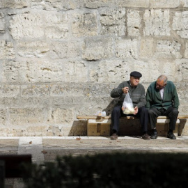 Ancianos en un banco en la localidad burgalesa de Briviescas. / AFP