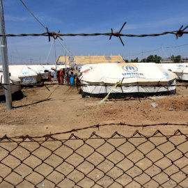 Varias familias permanecen fuera de las tiendas del campamento de Dibaga. - AFP