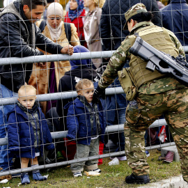 Miembros del ejército esloveno hablan con refugiados en la frontera con Austria. REUTERS / Leonhard Foeger