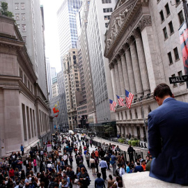 Un hombre sentado sobre un muro de mármol en frente del New York Stock Exchange, EEUU. / REUTERS