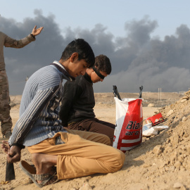 Un soldado iraquí junto a dos detenidos acusados de pertenecer al Estado Islámico, en un puesto de control en la localidad de Qayyara, al sur de Mosul. REUTERS/Goran Tomasevic