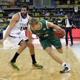 El alero lituano del Unicaja Málaga, Mindaugas Kuzminskas, se marcha ante el alero del Bilbao Basket, Alex Mumbrú. - EFE