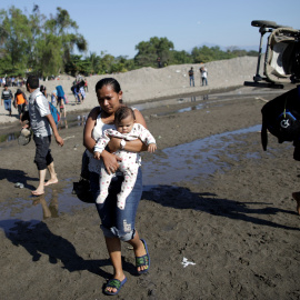 Migrantes de la caravana que viaja a Estados Unidos cruzando a la orilla guatemalteca del río en Ciudad Hidalgo, México. / Reuters