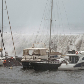 21/01/2020.- Grandes olas sobrepasan el espigón del Puerto Olímpico de Barcelona hundiendo uno de los barcos atracados. / EFE - ENRIC FONTCUBERTA