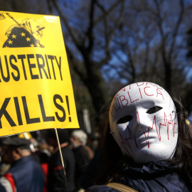 Una manifestante en la marcha de Madrid con una máscara y una pancarte que, en inglés, dice 'La austeridad mata'. REUTERS/Andrea Comas
