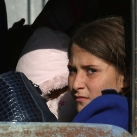 Una niña huye del conflicto en Siria. / REUTERS