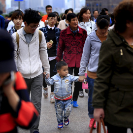 Un niño pequeño pasea de la mano de sus padres por las calles de Shanghai. REUTERS/Aly Song