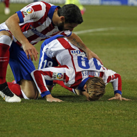 Torres besa el césped del Calderón tras marcar un gol en su vuelta al Atlético. /REUTERS