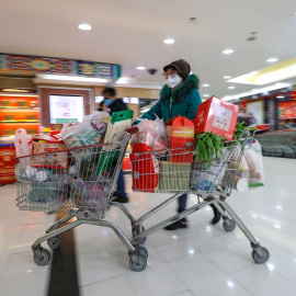 Una mujer con máscara compra en un supermercado en Wuhan. EFE