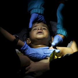 Médicos y paramédicos voluntarios tratan de revivir a un bebé después de que cayera al agua al volcar una embarcación que trasportaba a 200 refugiados desde Turquía hasta la isla griega de Lesbos.-REUTERS / Giorgos Moutafis