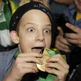 El afortunado joven que se llevó la medalla de Bill Williams. REUTERS/Henry Browne